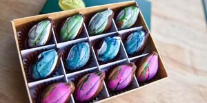 A box of colourful chocolates on a wooden counter