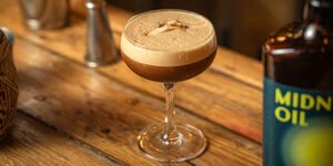 A cocktail in a glass on a wooden counter