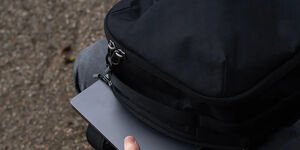 Image of a man removing a laptop from his backpack.