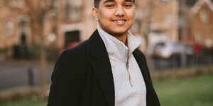 Image of a man in a suit smiling at the camera.