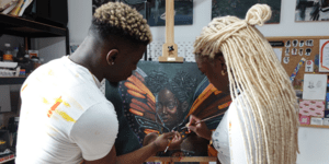 Image of Adwoa and Solomon painting together.