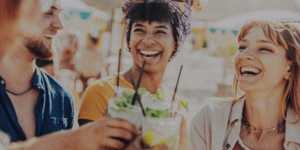 Image of three people drinking cocktails and smiling.