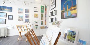 Image of a gallery hung with paintings.