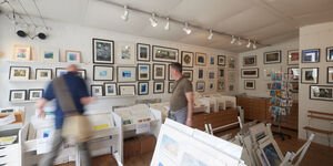 Image of people browsing the prints in the gallery.