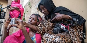 Image of two girls playing with a camera.