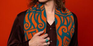 Image of a man wearing a green and orange scarf.