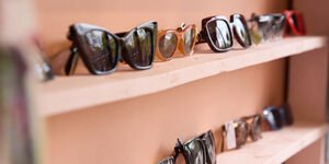 Two terracotta coloured shelves with a selection of sunglasses