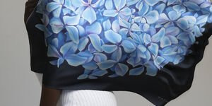 Woman wearing a blouse of blue hydrangeas.