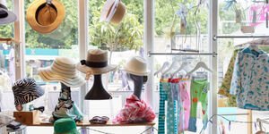 A selection of hats, headwear and children's clothes displayed in a shop window