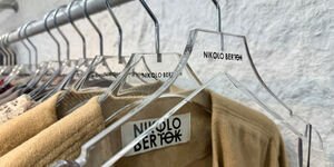 Image of coat hangers with a brown coat.
