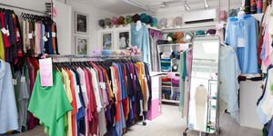 The inside of a shop with rails of wollen clothing