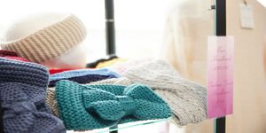 A close-up photograph of knitted headbands in different colours
