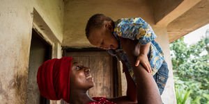 Woman holds up a baby