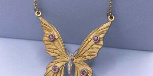 Image of a gold butterfly necklace.