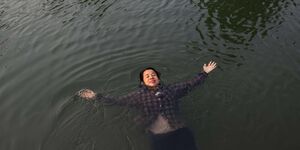 Image of a woman swimming in water.