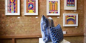 An image of a display of Gina's artwork on the wall.