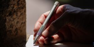 Image of someone writing with a pen.