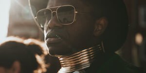 Image of a man wearing a hat and sunglasses.