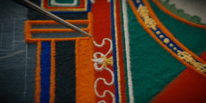 Image of a mandala being made with sand.