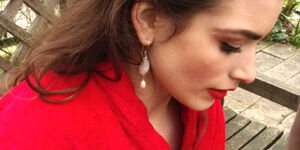An image of a woman in a red shirt wearing Catherine's earrings.