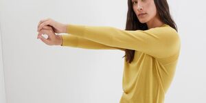 An image of a model wearing a yellow jumper.