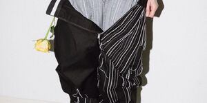 An image of a model wearing three pairs of trousers.