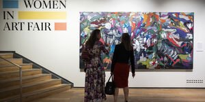 Image of two women looking at a painting.