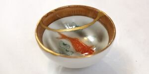 An image of a small ceramic featuring a painting of a goldfish.