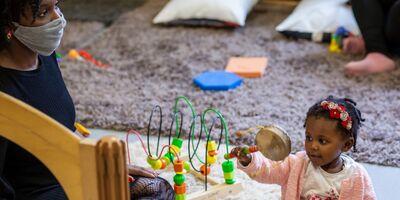 Baby and mother playing with musical instrument