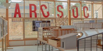 Image of the ARCSOC title in big red letters in an art studio.