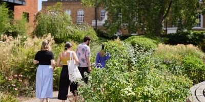 Image of 3 people walking through Bernie Spain Gardens.