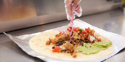 Image of someone making a burrito.