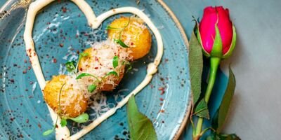 Image of a rose next to a romantic meal.