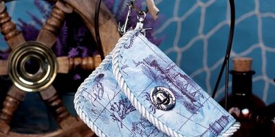 Image of a blue sea-themed purse hung up on a hook.