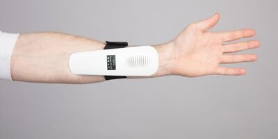 Image of a man wearing a device on his arm.