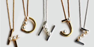 Image of a set of gold necklaces as initials.