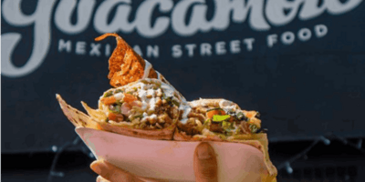 Image of a man holding up nachos.