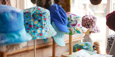 A selection of hats on wooden stands