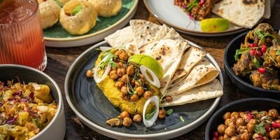 A selection of food on plates on a dark wood table.