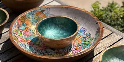 Painted wooden bowls on top of a wooden table
