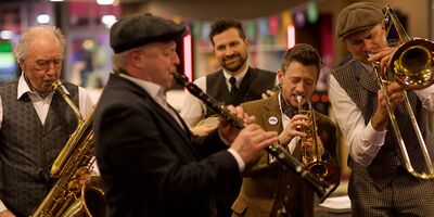 A group of musicians in the midst of playing brass and wind instruments
