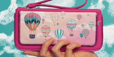 A pink purse decorated with stitched hot air balloons
