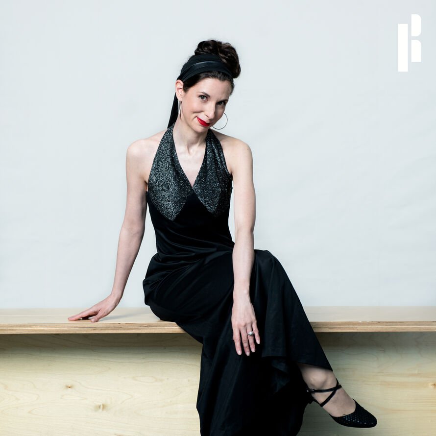 picture of Danielle posed on a bench, smiling at the camera