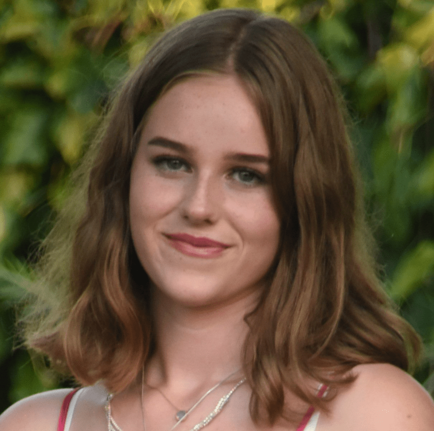 A picture of Ellie smiling in a garden