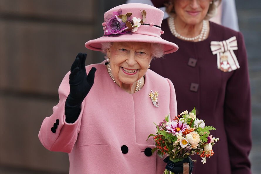 HM The Queen dressed in pink waving