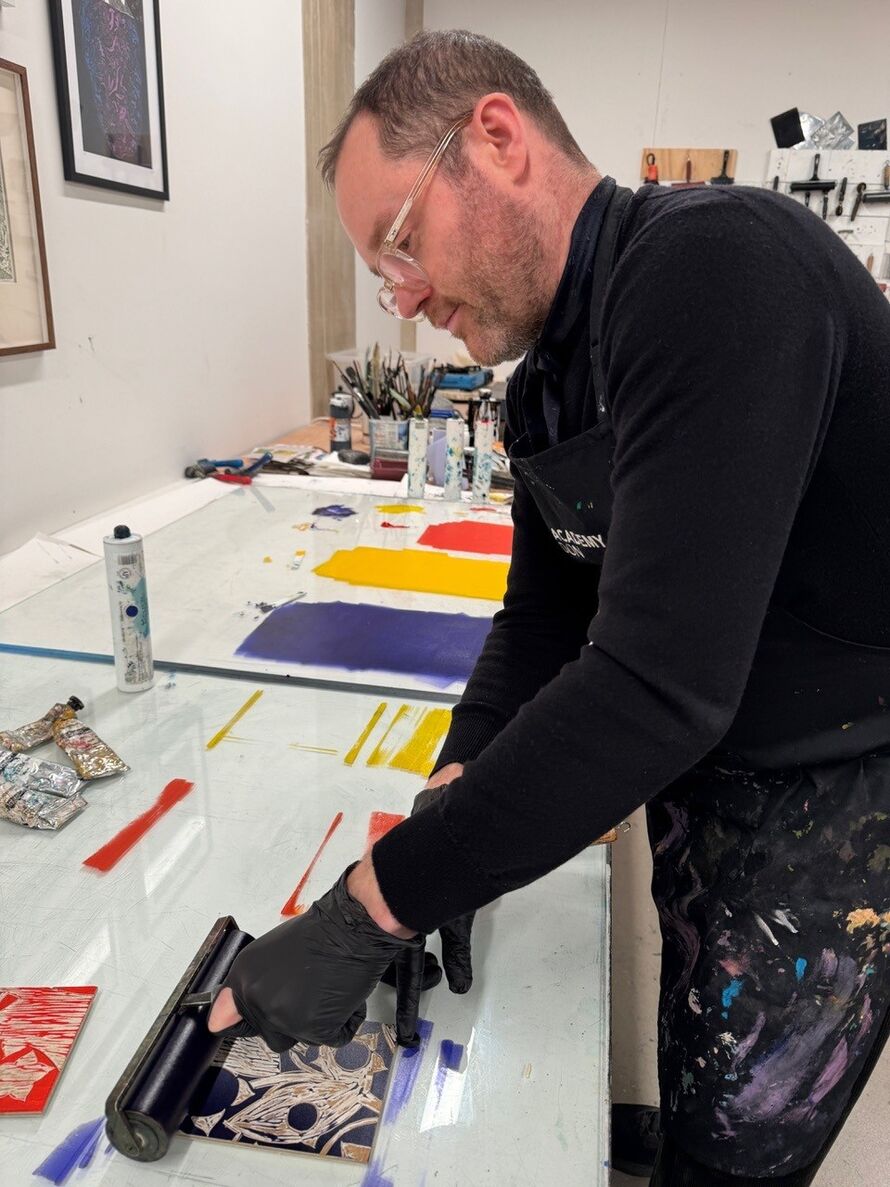 Image of Patrick printing in his workshop.