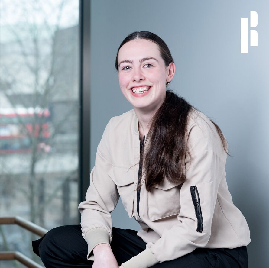 A picture of Rosie in a Rambert studio, smiling at the camera 