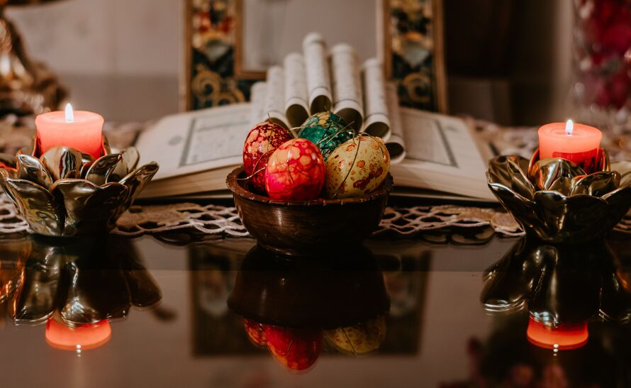 Image of a Haft Seen table, with a Qur'an and apples on the table.